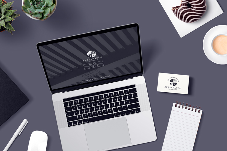 Laptop, Business Card, and Notepad on a Desk