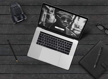 Laptop and Lens on a Black Wooden Background