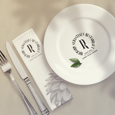 Teller mit eingewickelter Serviette und Besteck