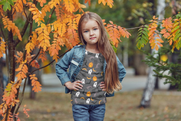 Little Girl Standing by an Autumn Tree