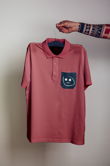 Tattooed Arm Holding Hanger with a Polo Shirt