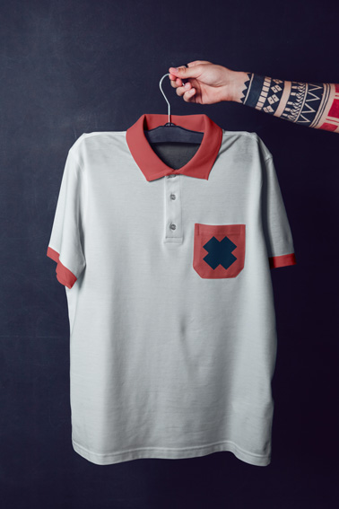 Tattooed Arm Holding Polo Shirt on a Hanger