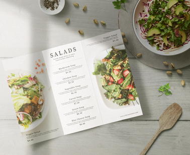 Folleto de menú abierto junto a una ensaladera