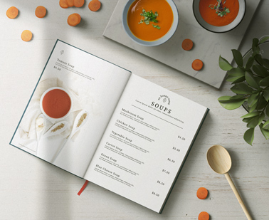 Menú de tapa dura abierto junto a tazones de sopa