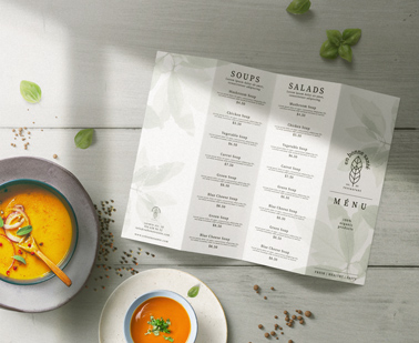 Folleto de menú abierto sobre una mesa de comedor