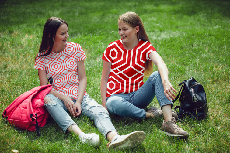 草の上に座っている二人の女子高生