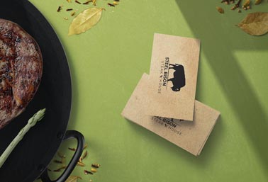 Pile de cartes de visite à côté d'un steak grillé