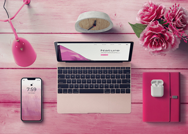 A Macbook with an iPhone and Stationery