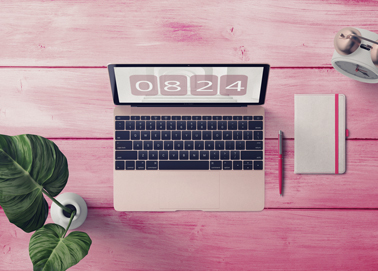 A Macbook With a Notebook High Angle View