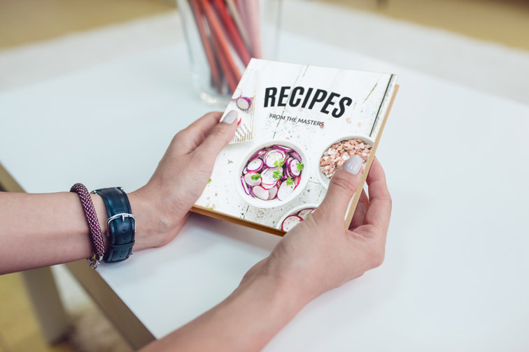 Hands Holding a Book at the Table
