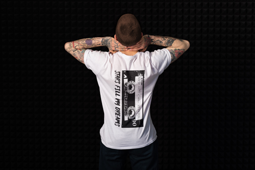 Мужчина стоит, держа руки на затылке