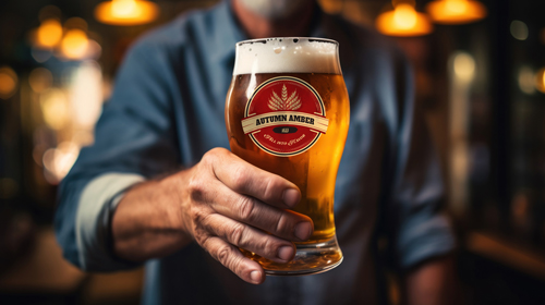 Бармен держит бокал с пивом