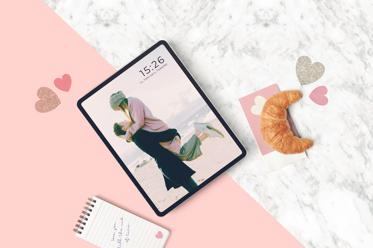 Tableta y cruasán sobre un fondo de San Valentín