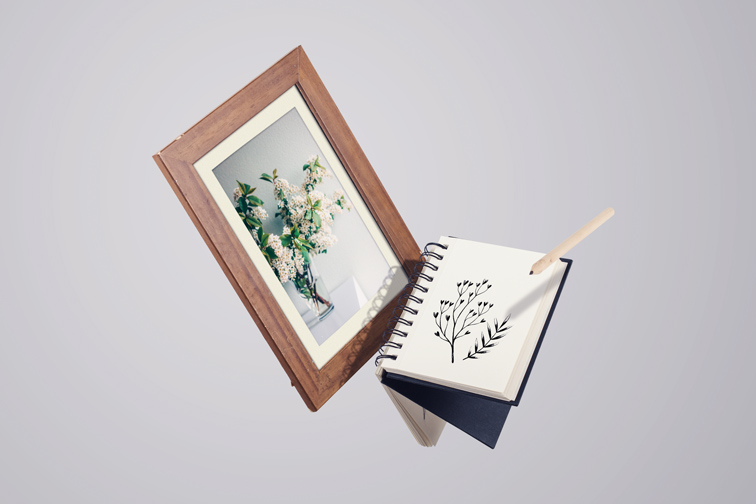 Cadre en bois avec un carnet de croquis et un crayon