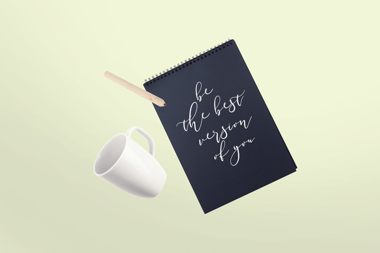 飛翔の垂直なスケッチブックや鉛筆、カップ